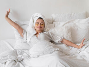 Dulces sueños mujer descansando en cama con ropa de seda y toalla en cabeza, cuidado de la piel, relajación, bienestar, belleza.